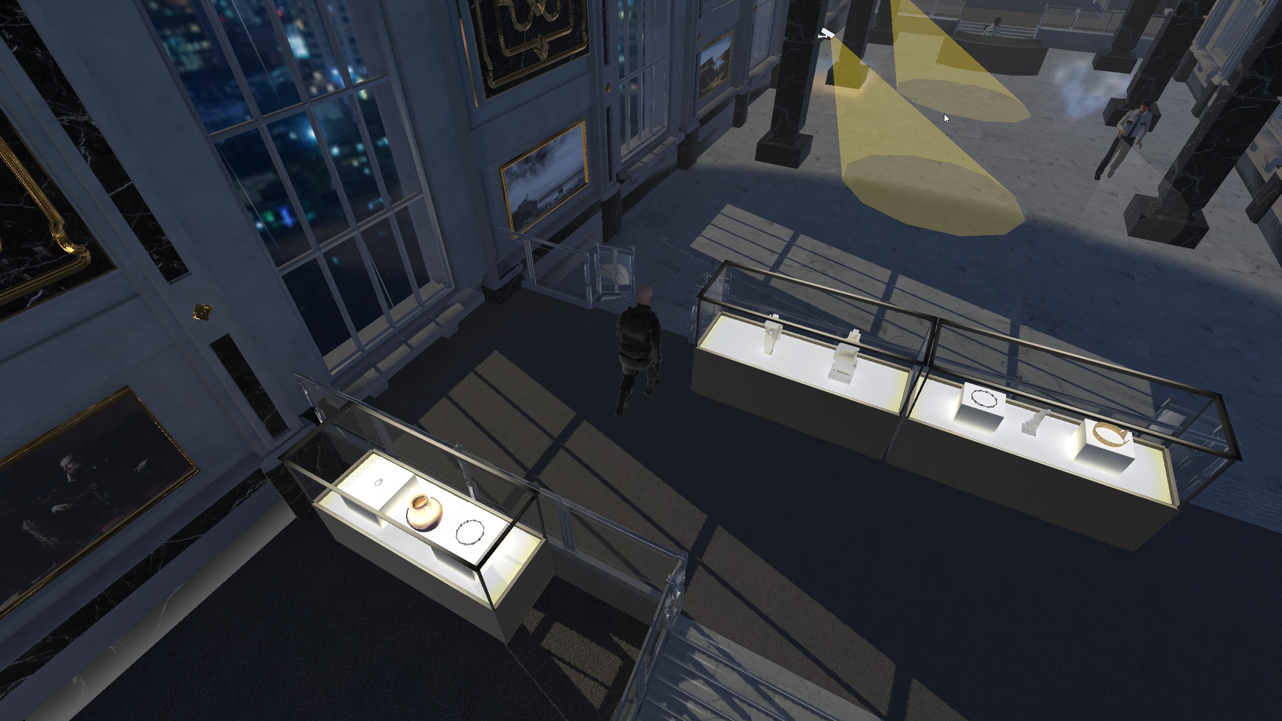 Screenshot from The Great Fleece showing an richly decorated and luxurious museum interior where the game is set.
The museum features marble floors and dark marble columns, with large golden chandeliers hanging from the ceiling.
The main floor is filled with glass display cases showcasing various valuable items.
Multiple security guards patrol the area. The player's character is seen at starting position of the level hidden behind some cases.